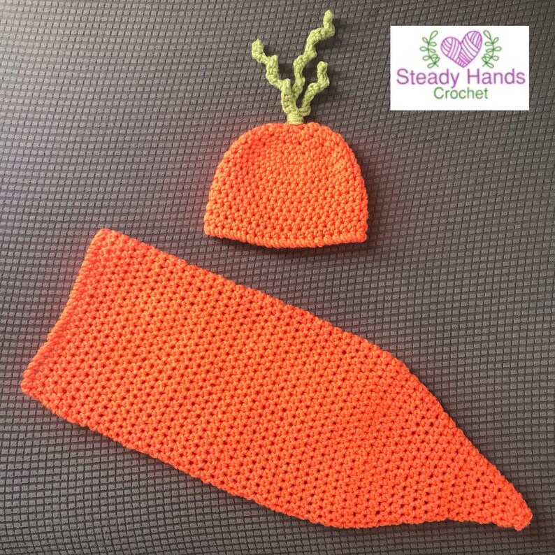 May include: A crocheted carrot costume for a baby, featuring a hat with green leafy top and a long, orange body.