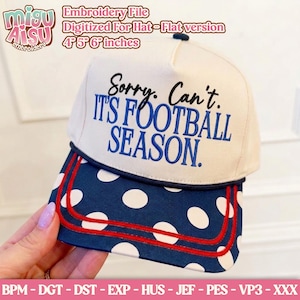 Op de afbeelding: Een crèmekleurige baseballpet met een marineblauwe klep met witte stippen en twee rode horizontale strepen. Het voorpaneel toont de geborduurde zwarte en blauwe tekst: Sorry. Can't. IT'S FOOTBALL SEASON. De pet heeft een marineblauwe knoop.