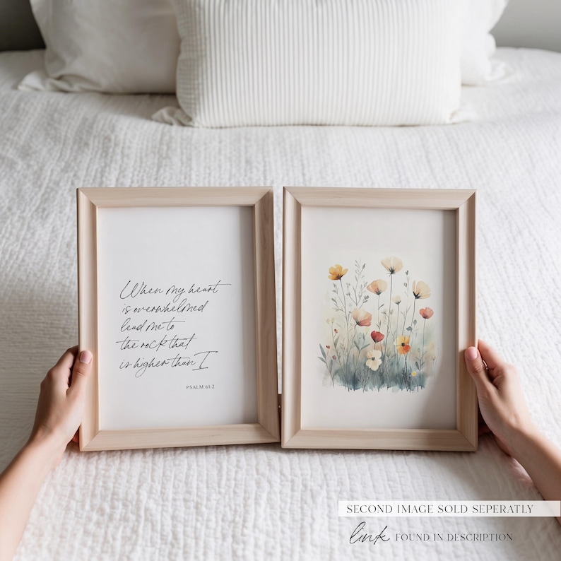 Puede incluir: Dos impresiones enmarcadas, una con una pintura de acuarela de flores silvestres y la otra con una cita manuscrita del Salmo 61:2, "Cuando mi coraz&oacute;n est&aacute; abrumado, gu&iacute;ame a la roca que es m&aacute;s alta que yo."