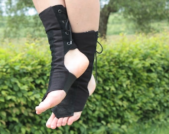 Peut inclure: Une paire de bottines noires à lacets remontant à l'arrière de la jambe. Les bottines sont en matière souple et flexible et ont une pointe pointue.
