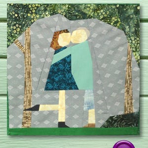May include: A patchwork quilt block depicting a couple embracing in a forest setting. The quilt block is made of various fabrics in shades of green, blue, and brown. The couple is made of fabric squares sewn together to form their bodies and faces. The background is a gray fabric with a white diamond pattern.