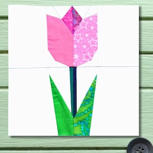 May include: A fabric tulip block with pink petals, a green stem, and green leaves. One petal side features a star pattern. The tulip is set against a white background, perfect for quilting projects.