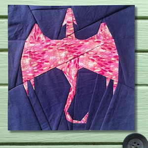 May include: A square fabric art piece featuring a stylized pink flamingo design against a dark blue background. The flamingo is composed of pink fabric with a leaf pattern. The background is made of dark blue fabric pieces.