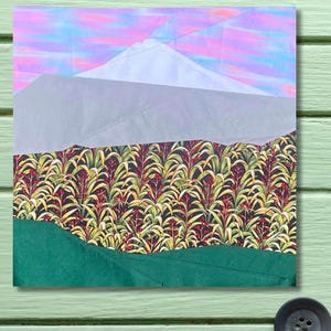 May include: A mixed media artwork featuring a mountain landscape. The sky is a blend of pink and blue hues, with a white mountain peak. Below, a patterned field of green and red plants sits above a green foreground.