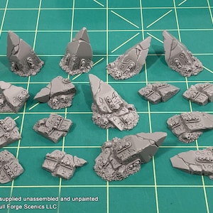May include: A set of 14 gray, unpainted, resin miniature ruins with intricate details. The ruins are designed to be used in tabletop games and wargaming.
