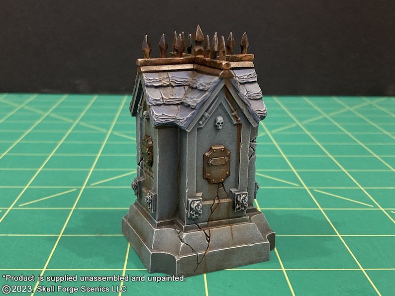 May include: A small, gray, stone mausoleum with a rusty brown roof and metal spikes. The mausoleum has a skull and crossbones design on the front and a metal plaque.