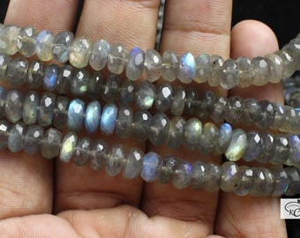Puede incluir: Una hebra de cuentas de piedra preciosa de labradorita gris y azul. Las cuentas son facetadas y tienen un acabado brillante e iridiscente.