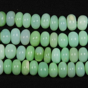Peut inclure: Un brin de perles d'opale vert clair. Les perles sont rondes et lisses, et elles ont un léger éclat iridescent.