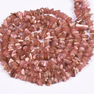 May include: A strand of pink and white gemstone chips. The chips are irregular in shape and have a natural, rough texture.