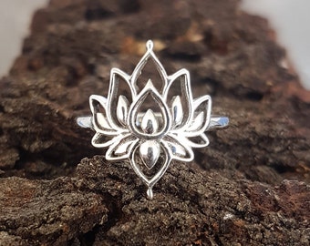 Puede incluir: Un anillo de plata con un diseño de flor de loto. El anillo es delicado e intrincado, con un patrón floral detallado.