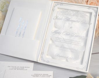 Caja blanca para invitaciones de boda: invitación de acrílico y pétalos de rosa.