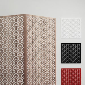 Può includere: Un divisor di ambiente in legno con un motivo decorativo a forma di cuore. Il divisorio è composto da quattro pannelli ed è mostrato in una stanza bianca con un divano rosso in primo piano. Il divisorio è mostrato in tre colori diversi: bianco, nero e rosso.