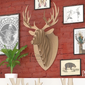 Könnte beinhalten: Ein Wandtrophäe aus Holz in Form eines Hirschkopfes, aus geschichtetem Holz, mit hellbrauner Oberfläche. Der Hirschkopf ist auf einem weißen Hintergrund montiert. Der Text "Cnc Factory Template Designer" ist in der unteren rechten Ecke des Bildes sichtbar.