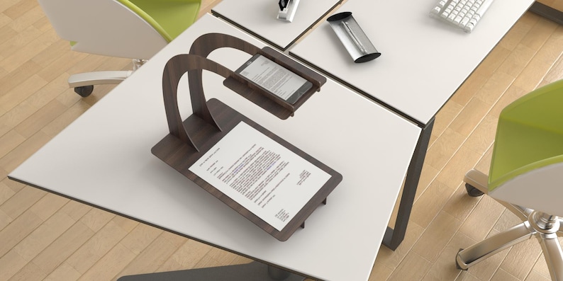 Op de afbeelding: Een houten standaard met een gebogen arm die een smartphone boven een vel papier houdt. De standaard staat op een wit bureau.