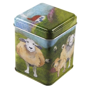 May include: A square green tin with a colorful illustration of sheep on a grassy hillside. The tin has a white rim and a blue sky with white clouds in the background.