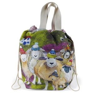 May include: A drawstring bag with a charming design of sheep wearing woolly hats. The bag has a cream-coloured handle and drawstring closure. The sheep are illustrated in a watercolour style against a green and purple backdrop.