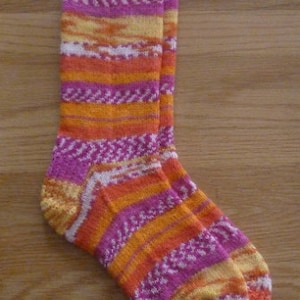 May include: A pair of colorful socks with a striped pattern in shades of pink, orange, and white.