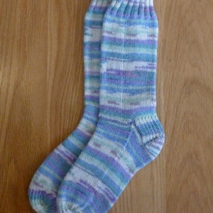 May include: A pair of socks in a blue, white and purple striped pattern. The socks are knitted and have a soft, comfortable feel.