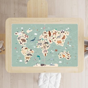 May include: A light wooden table with a world map design. The map is light green with illustrations of animals and continents. The table has a light wood frame and is viewed from above.
