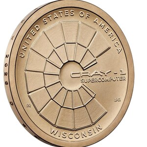 May include: A bronze-colored coin featuring the text "UNITED STATES OF AMERICA" and "WISCONSIN". The coin's center displays a geometric design with the text "CRAY-1 SUPERCOMPUTER". The year "2026" is also visible.