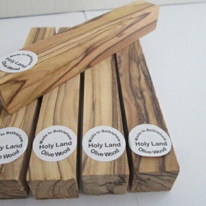 May include: Five pieces of olive wood, each with a round sticker that reads "Made in Bethlehem Holy Land Olive Wood".