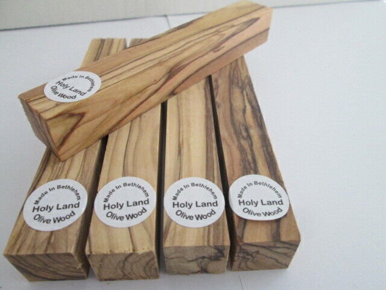 May include: Five pieces of olive wood, each with a round sticker that reads "Made in Bethlehem Holy Land Olive Wood".