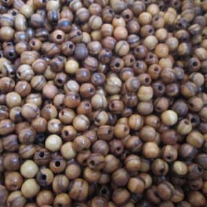 May include: A large pile of brown and light brown wooden beads with dark brown stripes. The beads are round and have a smooth finish.