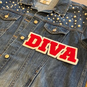 May include: A denim jacket with pearl embellishments and the word "DIVA" in red and white lettering. The jacket has gold-colored buttons and a classic collar. The Old Navy label is visible.