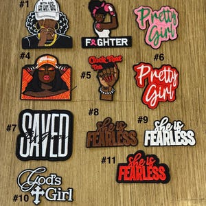 May include: A collection of embroidered patches with various designs and text. The patches feature phrases like "Pretty Girl," "Saved," and "She is Fearless," along with illustrations of women and inspirational quotes. The patches are in various colors.