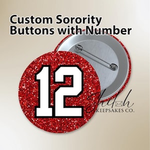 May include: Custom sorority buttons with the number 12 in white on a red glitter background. The buttons are round with a silver metal backing and a pin. The text "Custom Sorority Buttons with Number" is at the top.