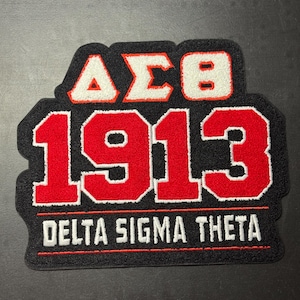 May include: A black embroidered patch featuring the Greek letters Delta Sigma Theta in white with red outlines, the number 1913 in large red digits with white outlines, and the text DELTA SIGMA THETA in white capital letters below a red line.