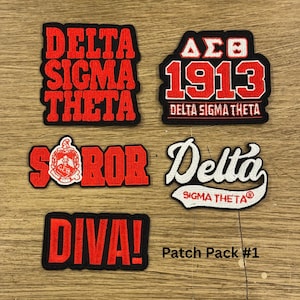 May include: A collection of five embroidered patches. The patches feature the words "DELTA SIGMA THETA", "1913 DELTA SIGMA THETA", "SOROR", "DIVA!", and "Delta SIGMA THETA". The patches are red and white on a black background.