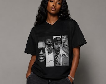 May include: A black short-sleeved V-neck t-shirt featuring a graphic print of four vertical panels displaying black and white portraits of individuals. The shirt is paired with dark gray denim jeans, creating a casual look with a distinct graphic design.