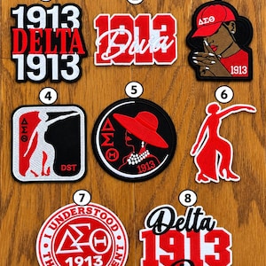May include: A collection of eight embroidered patches featuring Delta Sigma Theta themes in red, white, and black. Designs include the text 1913, Delta, Diva, and The Understood Assignment, alongside silhouettes of figures, Greek letters, and hats.