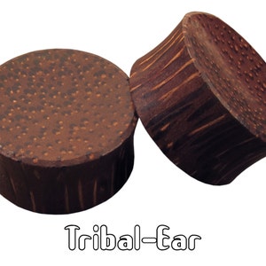 May include: Two dark brown wooden ear plugs with a textured surface and a flared design. The plugs are cylindrical with a flat, round face. The text "Tribal-Ear" is displayed below the plugs.