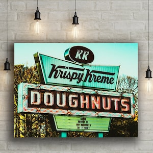 May include: A vintage Krispy Kreme Doughnuts sign with neon lights. The sign is green and white with the words "Krispy Kreme Doughnuts" in red and white neon letters. The sign also has a smaller sign that says "Come enjoy the taste of our doughnuts. Try it today!"