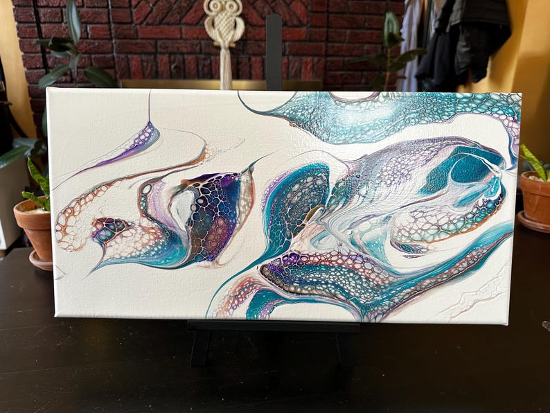 K&ouml;nnte beinhalten: Ein rechteckiges Leinwandgem&auml;lde mit einem abstrakten, fl&uuml;ssigen Acryl-Gie&szlig;design. Die Komposition zeigt wirbelnde Muster in Petrol, Dunkelblau, Violett und metallischem Kupfer auf einem rein wei&szlig;en Hintergrund mit sichtbaren Zellstrukturen.