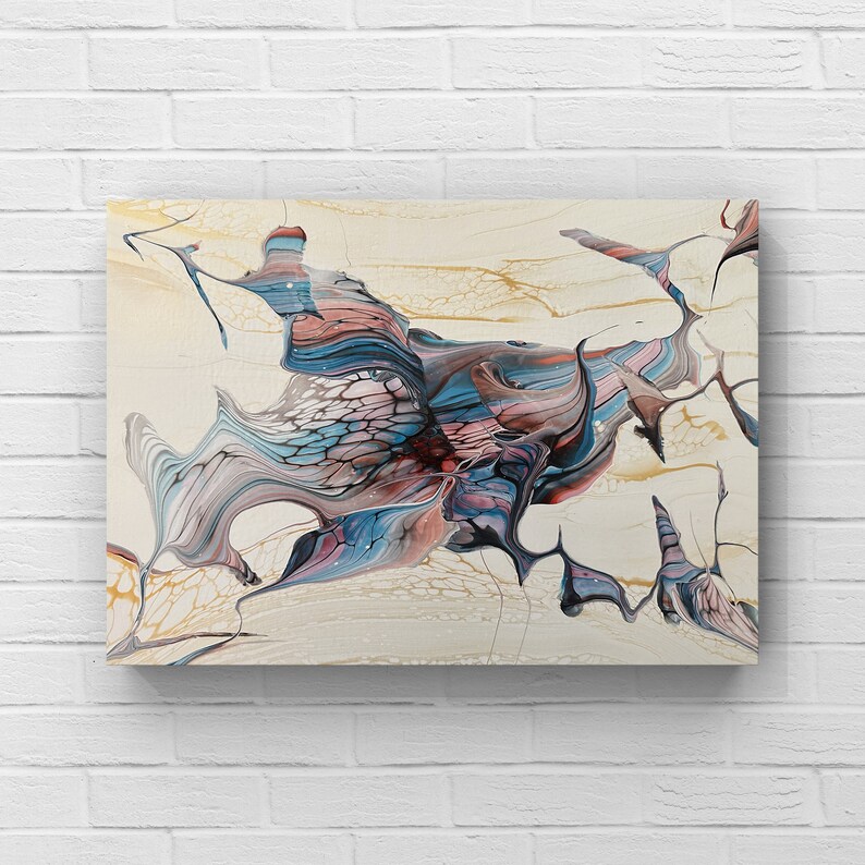 May include: Abstract canvas art featuring a fluid design with a mix of colors. The artwork showcases flowing patterns in shades of blue, pink, and gray against a cream-colored background. Gold accents add a touch of elegance to the piece.