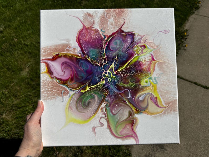 Pu&ograve; includere: Una tela quadrata che presenta un dipinto acrilico astratto con un design centrale simile a un fiore. La composizione mostra vortici vibranti di magenta, viola intenso, giallo brillante e verde acqua, accentuati da intricati motivi cellulari bianchi e dorati.