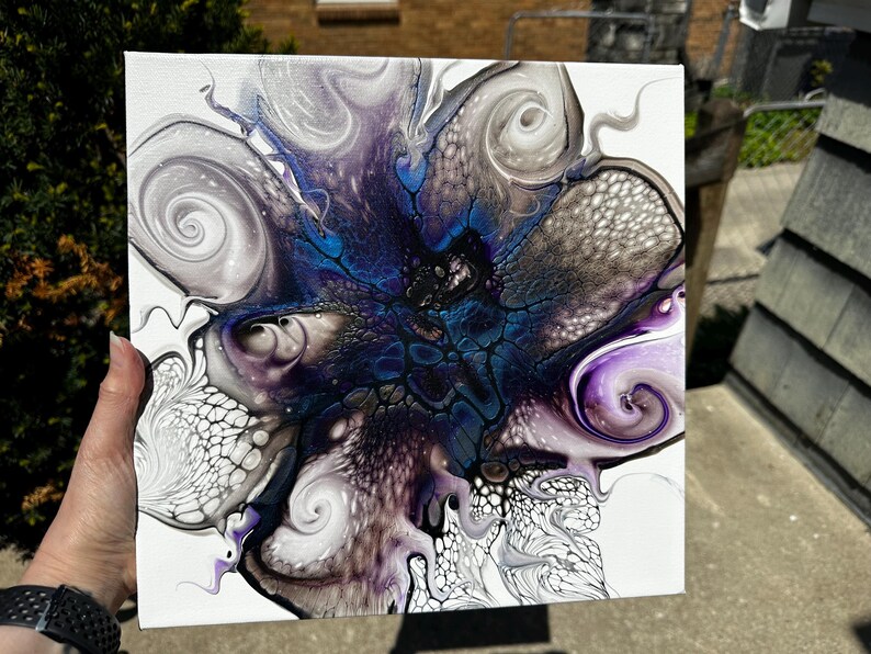 Puede incluir: Un lienzo cuadrado con una pintura acr&iacute;lica abstracta sobre fondo blanco. El dise&ntilde;o muestra patrones de remolinos en azul profundo, morado, negro y plata met&aacute;lica, creando estructuras org&aacute;nicas similares a c&eacute;lulas y formas fluidas y veteadas.