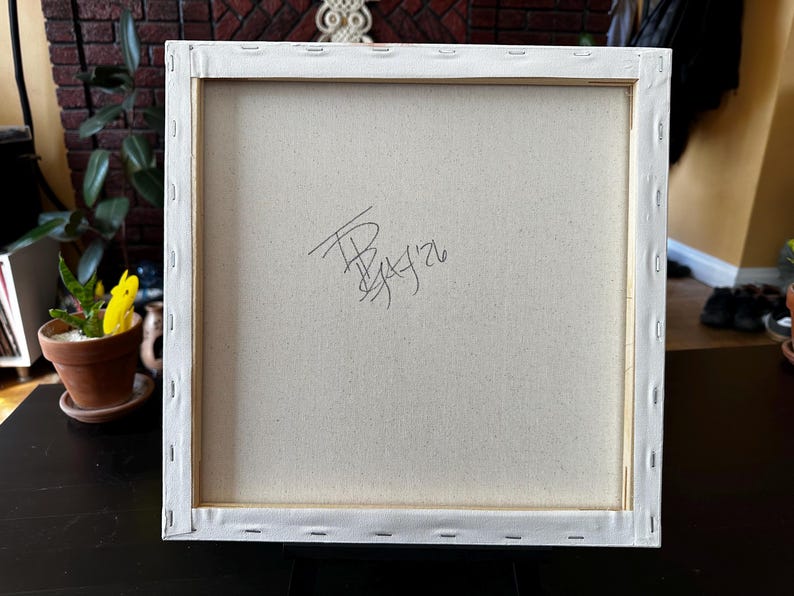 Pu&ograve; includere: Il retro di una tela quadrata tesa su un telaio in legno. Il tessuto bianco sporco &egrave; fissato alle barre di legno con punti metallici lungo i bordi. Una firma scritta a mano in nero e la data '26 sono visibili al centro della tela.