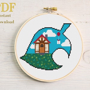 Pode incluir: Design de ponto cruz num bastidor de madeira com uma casa, nuvens e um balão dentro de uma forma de folha. O texto "PDF Instant Download" está no topo. O design está num fundo branco.