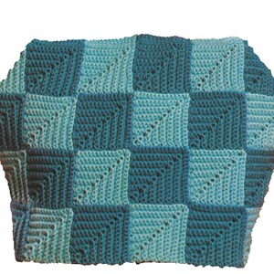 Op de afbeelding: Een gehaakt deken met een geruit patroon in tinten teal en aqua.