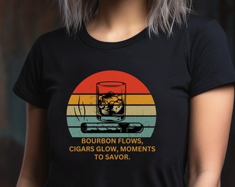 May include: Black t-shirt with a vintage-style graphic of a glass of bourbon and a cigar with the text "Bourbon flows, cigars glow, moments to savor."