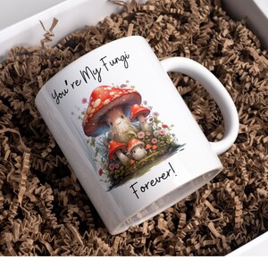 May include: White ceramic mug with a red and white mushroom illustration and the text "You're My Fungi Forever!"