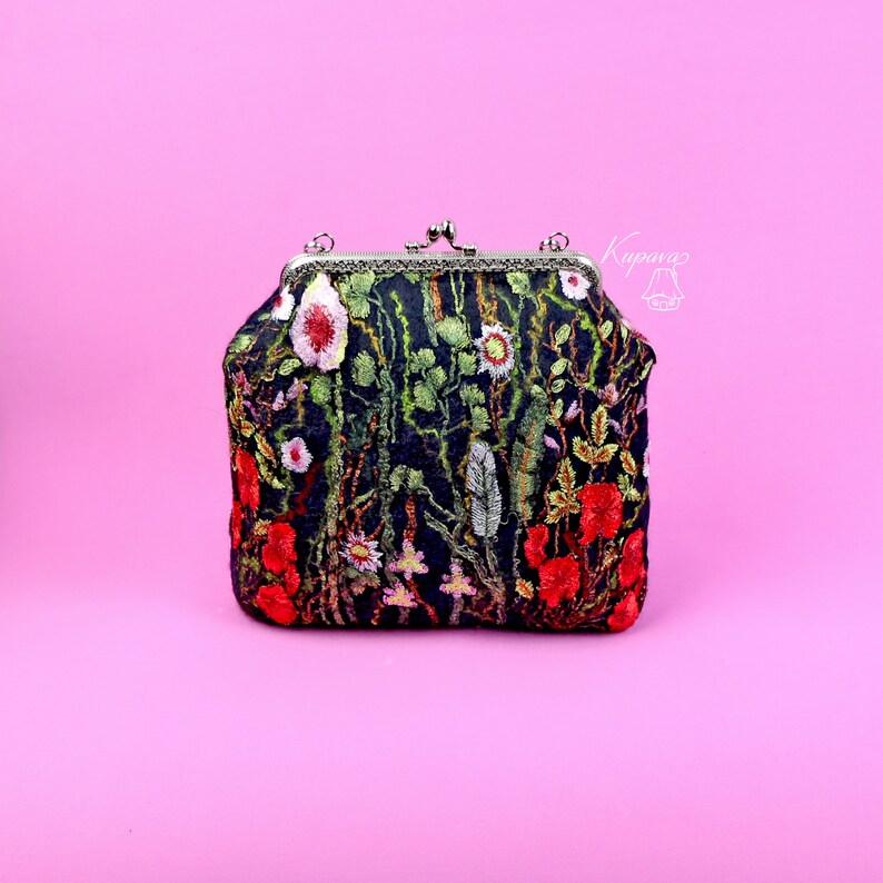 May include: A black velvet clutch bag with a floral embroidery design featuring red, pink, and green flowers. The bag has a silver clasp and a chain strap.
