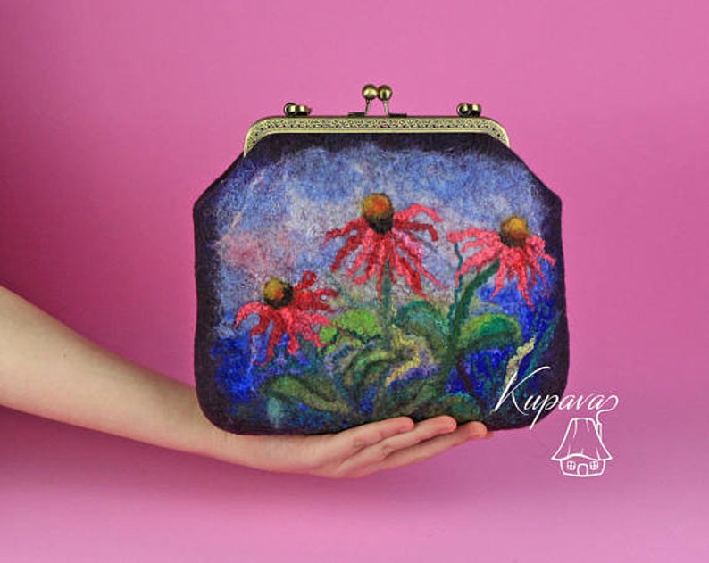 May include: A dark purple felt clutch bag with a floral design. The flowers are red, pink, and white and are painted on the front of the bag. The bag has a metal clasp and a small metal handle.