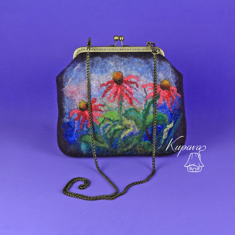 May include: A small, dark blue felt clutch bag with a floral design featuring red flowers and green leaves. The bag has a brass clasp and a chain strap.