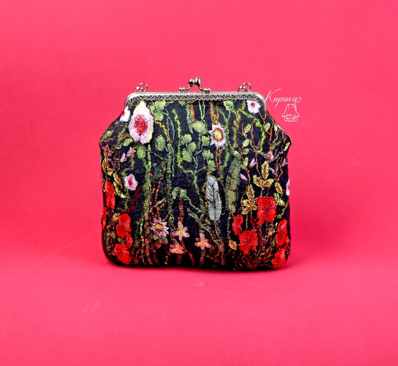 May include: A black fabric clutch purse with a floral embroidery design featuring red, pink, and green flowers. The purse has a silver clasp and a silver chain strap.