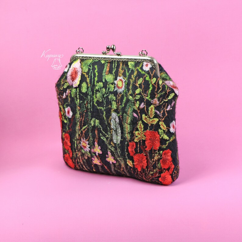 May include: A black fabric clutch purse with a floral embroidery design. The embroidery features red, green, and white flowers.